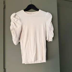 Vit topp med puffärm Monki - Supersöt vit ribbad topp från Monki i storlek XS. Modellen har korta puffärmar. 