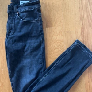 Mörkgråa slim fit jeans från BOSS - Snygga mörkgråa jeans från BOSS i modellen Delaware Slim Fit. Jeansen har klassisk femficksdesign, dragkedja och är tillverkade i stretchig denim för extra komfort. Perfekta för dig som gillar en smalare passform och stilren look.