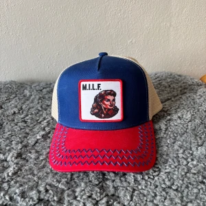 Revenite MILF keps - En Revenite keps som inte säljs längre med en kvinna på kepsen och ett  M.I.L.F tryck. Nypris 350kr från Revenites egna hemsida men säljs inte längre, mitt pris 249kr men kan fof diskuteras vid snabb affär. HELT OANVÄND! Pris ej hugget i sten