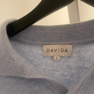 Davida Kashmir - Säljer en ljusblå stickad tröja från Davida i storlek S. Tröjan har klassisk krage och långa ärmar, perfekt för lager-på-lager. Mjuk och skön känsla, passar till många olika stilar.Skick 8/10 har en litet fläck som knappt syns och är enkel att ta bort. 