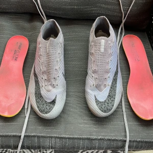 Nike Mercurial Fotbollsskor Elite FG "Rising Gem” Grå/Svart - Säljer ett par Nike Mercurial fotbollsskor som är i storlek 41 och är i ganska bra skick, 8/10, inga hål i skorna men bara lite slitna på undersidan och har fått lite svart färg från konstgräset och lådan kommer självklart med men påse kommer inte med, pris kan diskuteras!