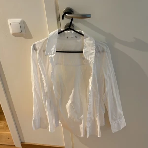 Vit skjorta från MNG - Klassisk vit skjorta från mango med lång ärm och krage. Perfekt för en clean och stilren look. Skjortan har knappar framtill och är tillverkad i ett mjukt material som känns bekvämt mot huden.