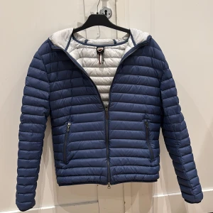 Blå pufferjacka från Colmar - Snygg blå pufferjacka från Colmar med quiltad design och dragkedja framtill. Den är andvänd några gånger och är i riktigt bra skick.