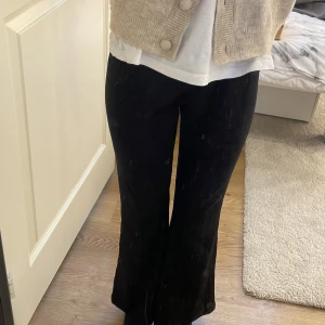 Svarta ribbade byxor från H&M - Svarta ribbade byxor från H&M med utsvängda ben. Byxorna har en mjuk och stretchig känsla, perfekta för en avslappnad och trendig stil. Passar dig som gillar bekväma men snygga plagg.