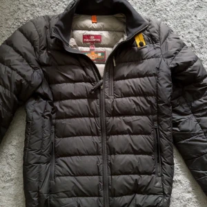 Svart dunjacka från Parajumpers - Säljer en svart dunjacka från Parajumpers. Den har ej använts på flera år och är i  bra skick men finns tecken på användning. Den motsvarar nog XS i storlek ungefär så passar yngre personer. Tveka inte på att skriva om du har några frågor eller funderingar. 