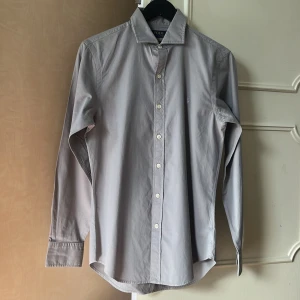 Ralph Lauren Skjorta - Hej! Säljer en stilren ljusgrå/beige skjorta från Polo Ralph Lauren i slim fit.  Den är feather weight twill så perfekt för sommaren. Skriv för frågor/funderingar! 