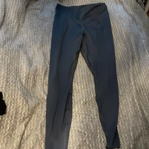 Svarta träningstights från H&M Move - Svarta tights från H&M Move i stretchigt material. Perfekta för träning med hög midja och tight passform. Snygga och bekväma att röra sig i, passar till gymmet eller löprundan.