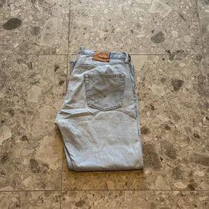 Ljusblå Levis 501 jeans - Säljer ett par klassiska ljusblå Levis 501 jeans. Storlek W36, L32. Väldigt snygga jeans enligt mig och är i helt ok skick. Nypriset ligger på cirka 1400 så ett väldigt bra pris.