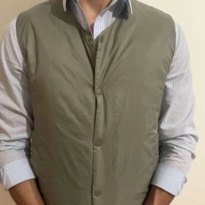 Olivgrön väst från Selected Homme - Säljer en stilren olivgrön väst från Selected Homme. Västen har en enkel design med knäppning framtill och v-ringad hals. Perfekt att bära över skjorta för en snygg lager-på-lager-look. ( använd max 3 gånger ) NY PRIS 800kr 