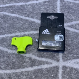 Vita Adidas Copa fotbollsskor med gröna dobbar - Säljer ett par vita Adidas Copa fotbollsskor med snörning och gröna dobbar. Skorna har en klassisk design med tre vita ränder på sidan och är tillverkade i skinn. Perfekta för dig som vill ha stilrena och bekväma skor på planen.