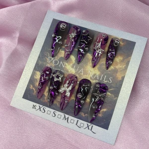 VioletVortex (XS);Long Stiletto  - Snygga långa gelé press-on naglar i lila, svart och rosa med metallic-effekt, dekorerade med silvriga stjärnor, fjäril och små pärlor. Naglarna har en spetsig form och coolt mönster som verkligen sticker ut. Perfekt för dig som vill ha unika och trendiga naglar utan att gå till salong. I storlek XS: 14 mm, 11 mm, 11,5 mm, 10 mm, 8 mm 