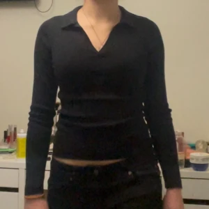 Svart ribbad polotröja från H&M - Säljer en svart, ribbad polotröja från H&M i storlek XS. Tröjan har v-ringning, krage och lång ärm. Den är figurnära och stretchig, perfekt till jeans eller kjol. Enkel och stilren design som funkar året runt. Ha i åtanke att jag vanligtvis har storlek S och ibland M så tröjan sitter ej proprrionellt ’rätt’ på mig. Meddela om ni har frågor eller vill ha närbilder😇 