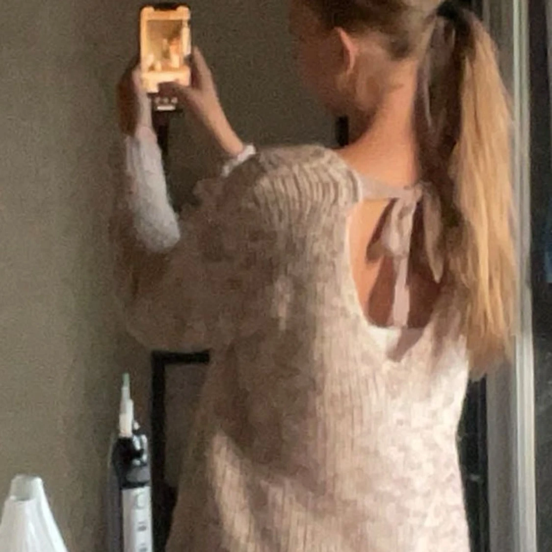 Beige stickad tröja med rosett i ryggen