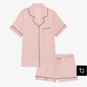 Anne field  Rosa pyjamas set - Säljer ett par ljusrosa pyjamasshorts från Anna Field med svarta kantdetaljer och snörning i midjan. Shortsen är loose fit och har en mjuk, glansig känsla som passar perfekt för chillkvällar hemma.