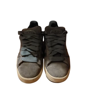 Adidas Campus sneakers i marinblå mocka - Snygga Adidas Campus sneakers i marinblå mocka med klassisk beige sula. Skorna har rund tå, breda blåa snören och diskret Adidas-logga på hälen. Perfekta för dig som gillar en stilren och tidlös look.