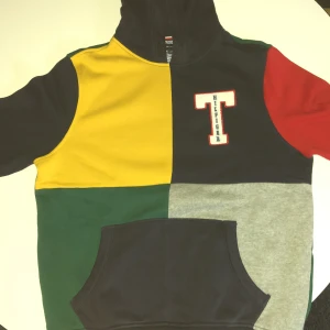 Färgglad hoodie från Tommy Hilfiger - Säljer en riktigt snygg hoodie från Tommy Hilfiger med färgblock i gult, grönt, rött, grått och mörkblått. Stor broderad 'T' på bröstet och 'TOMMY' på huvan. Klassisk känguruficka och mjukt bomullsmaterial. Perfekt för dig som gillar streetstyle. Använd 1 gång säljer för att jag inte gilla alla färger😁pris går att diskuteras😁