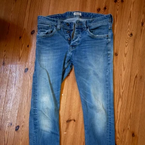 Blå jeans från Pepe Jeans London - Säljer ett par klassiska blå jeans från Pepe Jeans London med snygg slitning och ljusa partier. Jeansen har raka ben, fem fickor och knäppning med knappar. Perfekta för en avslappnad och cool stil.