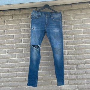Tiger of Sweden slim jeans blå 28/32 - Snygga blå jeans från Tiger of Sweden med slitna detaljer och hål på knäna. Modellen är slim fit med klassiska fem fickor. De är storlek 28:32 ungefär och passar allt i mellan 175-185. Inga deffekter. Nytt pris är 1600kr❌mitt pris är ett 399kr✅tveka inte skriv bara om det e nåt ni undrar