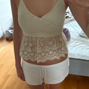 Beige stickad spetslinne från Zara - Supersöt beige linne från Zara med smala axelband, omlottstickad överdel och volangig nederdel i spets💗💗
