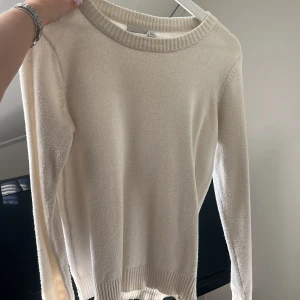 Vit stickad tröja från VILA - Supermjuk vit stickad tröja från VILA med rund halsringning och ribbade muddar vid ärmslut och nederkant. Perfekt basic till garderoben och enkel att styla med allt. Långärmad och i klassisk passform.