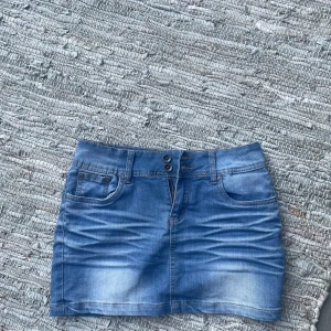 Blå jeanskjol från vs.miss - Snygg blå jeanskjol från vs.miss, bälteshällor och dubbla knappar i midjan. Perfekt för dig som gillar en enkel och tidlös stil. Kjolen har en lätt tvättad look och passar till allt.