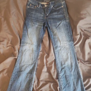 Blå bootcut jeans med broderade fickor - midwaist baggy/bootcut jeans. Jätte snygga. Säljs för att jag inte använder dem längre.  Storlek 36/S  Midja 38cm rakt över Total längd 101 cm