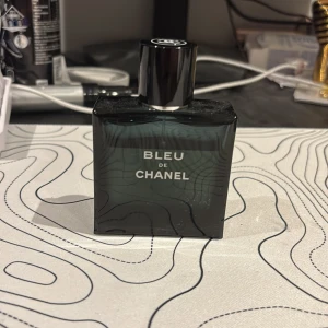 Bleu de Chanel Eau de Toilette 50ml - Snygg och stilren parfymflaska från Chanel, Bleu de Chanel Eau de Toilette 50ml. Flaskan är mörkblå, nästan svart, med silverdetaljer och klassisk Chanel-logga på korken. Perfekt för dig som gillar exklusiva och fräscha dofter. 759kr diskuterbart pris