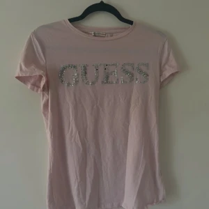 Guess T-Shirt - Saknar endast ett fåtal paljetter, kan fixas enkelt.                        Limited Edition köpt för 549kr. Passar Perfket med Y2K stilen. Pris kan diskuteras, tveka inte på att höra av dig💗