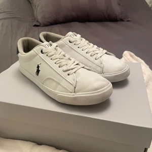 Polo Ralp Lauren skor  - Säljer ett par vita läder skor från Polo Ralp Lauren i storlek 38. Dom är väl använda men är i hyfsat skick 