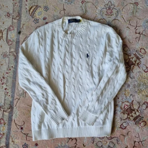 RALPH LAUREN KABELSTICKAD TRÖJA- vit - Nu säljs denna stiliga kabelstickadde tröjan i storlek s. Kontakta vid intresse. 