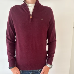 HELT NY MORRIS HALF ZIP - Snygg vinröd tröja från Morris i mjuk merinoull. Tröjan har half zip med läderdetalj, ribbade muddar och diskret logga på bröstet. Perfekt till jeans eller chinos för en clean look. Långärmad och med klassisk passform.