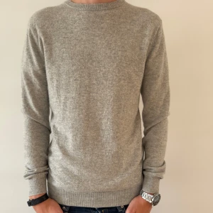 JOHN HENRIC KASHMIR TRÖJA - Mjuk och stilren grå tröja från John Henric i kashmir. Klassisk rund halsringning och ribbade muddar. Perfekt för dig som gillar en clean och enkel look med premiumkänsla. Passar lika bra till jeans som till chinos.