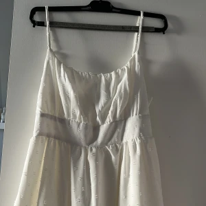 Vit klänning med smala axelband - Charmig vit klänning med smala axelband och subtilt mönster. Perfekt för studenten💕 knappt använd💕