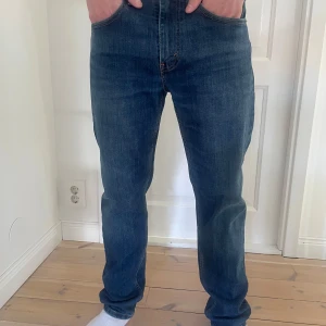 Levi's 502 jeans - Säljer ett par klassiska Levi's 502 jeans i en snygg mörkblå tvätt. De har en normal passform med raka ben och är tillverkade i slitstarkt denim. Perfekta för en avslappnad stil. Tyvär så har lappen där bak gått lite sönder men ingeg som märks vid användning!