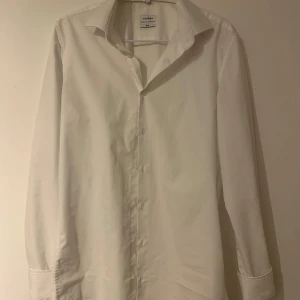 Vit skjorta från Seidensticker - Riktigt fin vit skjorta från Seidensticker i slim fit. Skjortan har långa ärmar och en diskret broderad detalj med en svart blomma. 