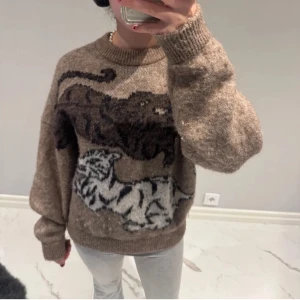 Beige/brun stickad tröja från Carin Wester - Intressekoll på min fina stickade tröja från Carin Wester. Brun med tigrar i svart och vitt. Storlek S, från Carin Wester, endast använd ett fåtal gånger. Nypriset ligger på 700kr. 