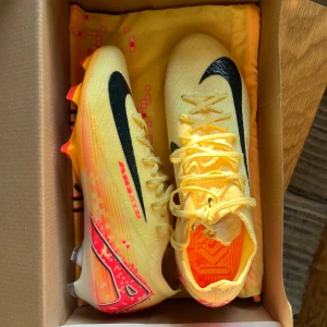 Fotbollsskor Nike ZM Vapor 16 Elite KM FG  - Nike ZM Vapor 16 Elite KM FG fotbollsskor. Helt oanvända, säljer för att det inte går att returnera skorna pga en defekt på dobben (se sista bilden). Ny pris: 3 499kr. Skriv för fler bilder och frågor