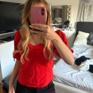 Röd linnetopp från H&M - Säljer en snygg röd linnetopp från H&M i storlek 36. Toppen har en v-ringad design och korta ärmar, perfekt för sommardagar. Materialet är en blandning av linne vilket ger en skön och luftig känsla. Passar utmärkt till både jeans och kjol.