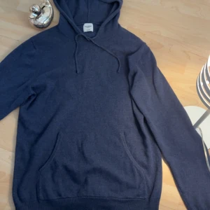 Mörkblå kashmir hoodie från John Henric - Säljer en stilren mörkblå hoodie från John Henric i mjuk kashmir. Tröjan har en klassisk design med huva och dragsko samt en praktisk magficka. Perfekt för kyliga dagar! Skick 7/10 funkar bra men inte helt ny skick lixom därmed priset, strl L men passar M bättre 