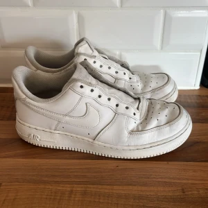 Vita Nike Air Force one - Säljer ett par klassiska vita Nike Air Force sneakers. Skorna har en stilren design och den ikoniska Nike-loggan på sidan. Perfekta för en avslappnad och sportig look. Snören medföljer, ingen box kvar. 