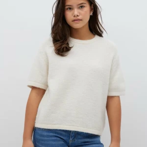 Vit kortärmad tröja - Säljer en stilren vit/beige tröja med korta ärmar. Tröjan har en enkel design och är perfekt för en avslappnad look. Den är mjuk och bekväm att bära. Från gina Young men blir som en kortare stickad T-shirt på mig som brukar ha S och är 170cm😇