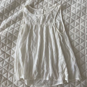 Vit ärmlös blus med spets KappAhl - vit blus från KappAhl i storlek 158. Toppen är ärmlös med fin spets upptill och lätt, plisserat tyg nedtill. Pris går att diskutera🙂