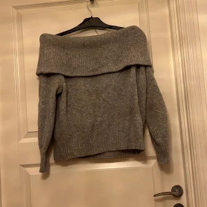 Stickad tröja  - En fin stickad tröja från hm i storlek xs utan axlar i färgen grå den är knopprig på några få ställen men annars inte 