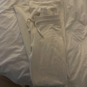 Vita lågmidjade mjukisbyxor  - Säljer ett par vita mjukisbyxor från Gina Tricot i storlek XS. Byxorna har resår och snörning i midjan för skön passform. Super fint skick, endast använda fåtal gånger.