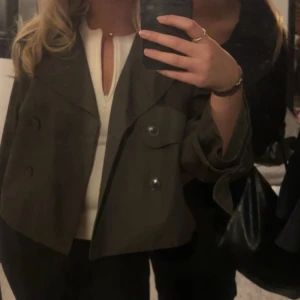 Grön kort trenchcoat  - Snygg olivgrön kort trenchcoat med stora knappar och bred krage. Väldigt bra skick❤️