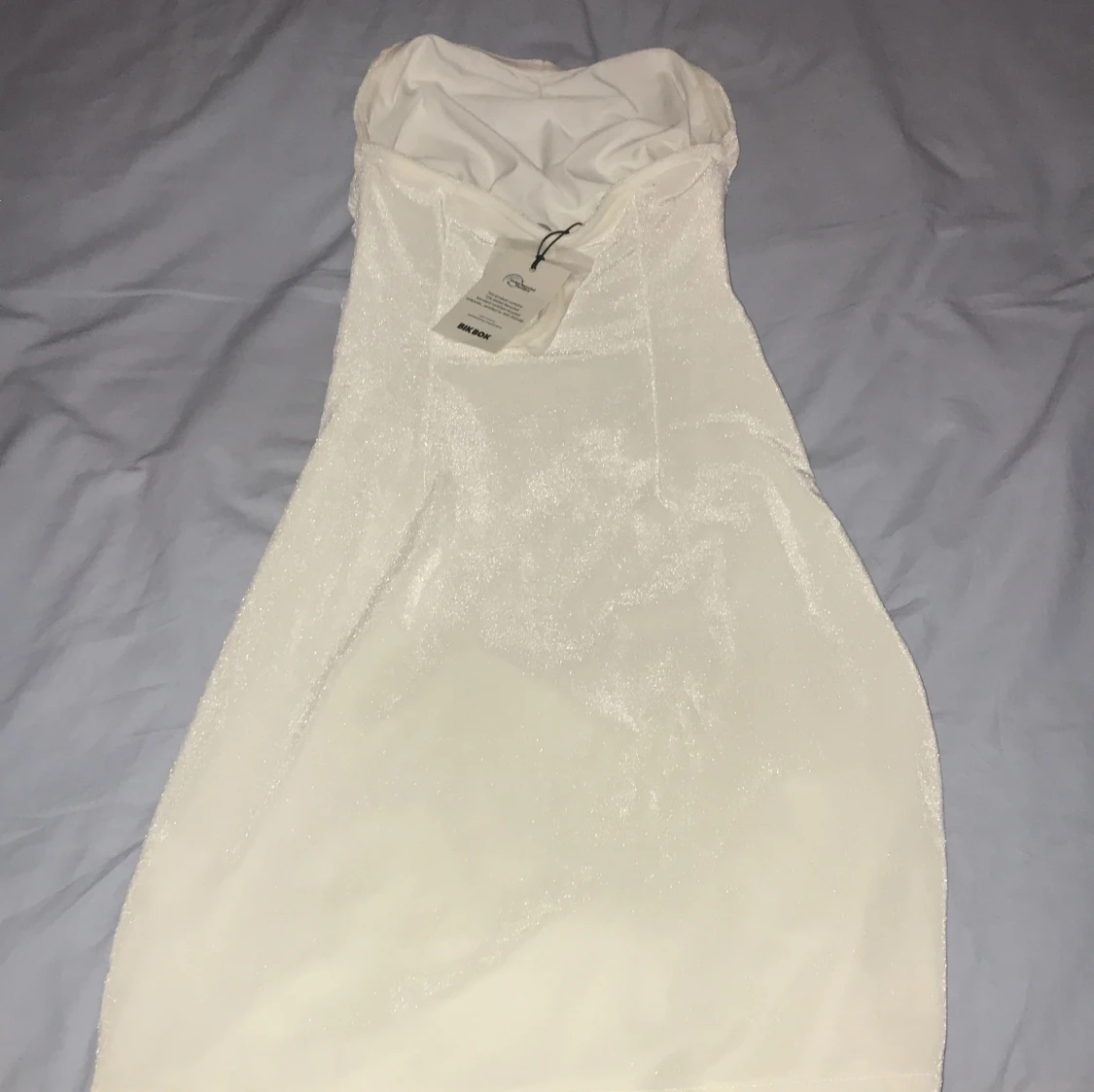 Glittrig vit axelbandslös klänning BikBok - 1