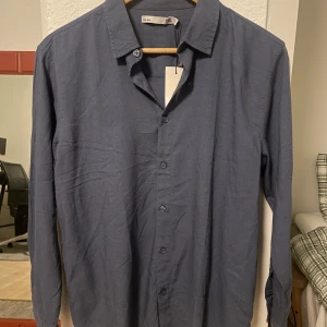 Skjorta - Säljer en helt ny blå skjorta från Lager 157 i storlek 160 men den upplevs vara någon storlek större. Den är aldrig använd och prislapp finns kvar. Bara att höra av sig vid frågor eller funderingar!