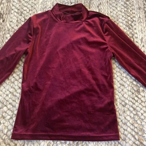 Vinröd sammets polotröja Gina Tricot - Vinröd polotröja i mjuk sammet från Gina Tricot. Storlek XS men materialet är stretchigt.