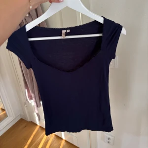 Mörkblå nellytopp - En stilren mörkblå topp med v-ringning och korta ärmar från Nelly. Strl xs. Pris 50 kr. 