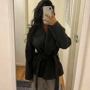 ONLY ONLAUGUSTA- grey melange - Snygg mörkgrå omlott kappa från ONLY med bred krage och knytskärp i midjan. Kappan har lång ärm och en stilren, minimalistisk look. Perfekt nu till hösten, eller vintern, lager på lager. Köpt för 749kr. 